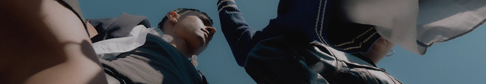 Low angle shot of people in stylish preppy clothing against a clear blue sky