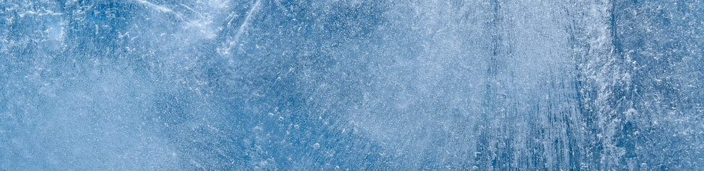 Close-up of blue ice texture with frozen air bubbles and crystalline patterns