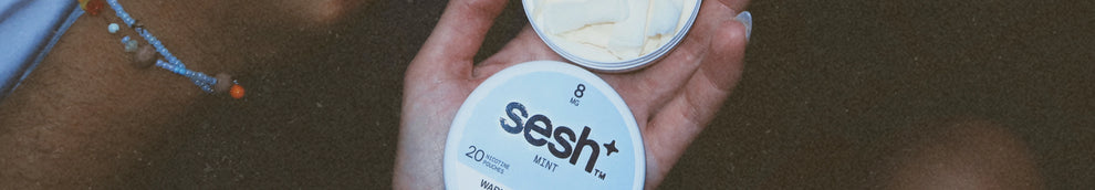 Hand holding an open tin of sesh+ mint nicotine pouches with 8mg strength